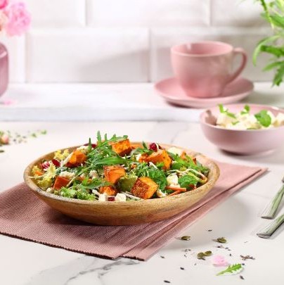 Salad with fried sweet potatoes, feta cheese and herbal dressing