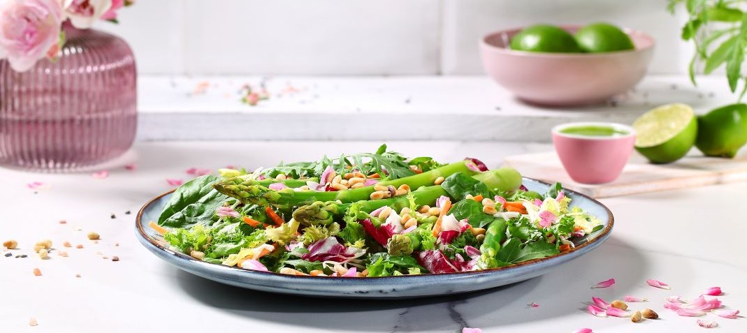 Green asparagus with rose petals on lettuce