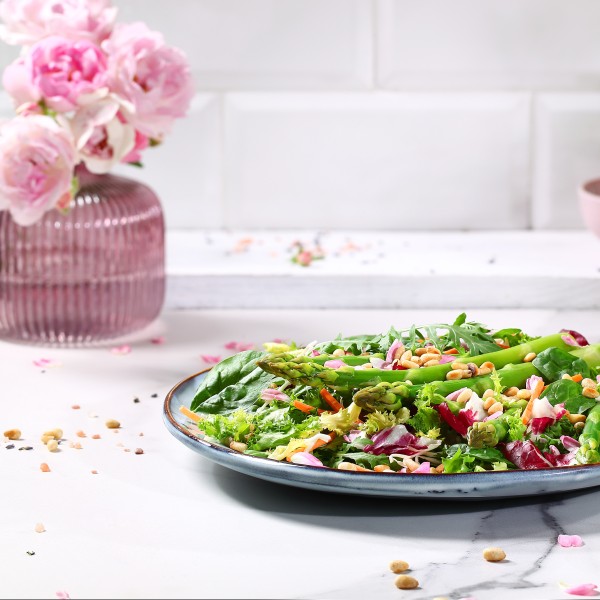 Green asparagus with rose petals on lettuce